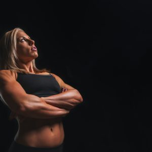 body builder woman wearing black crop-top cross armed closeup photography