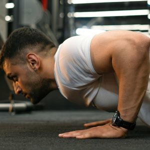 Man doing push-ups in a gym.